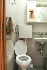 a bathroom with a white toilet and a sink at Apartments Astoria HN in Herceg-Novi