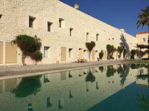 a building with a pool of water in front of it at Convento das Bernardas AZ in Tavira