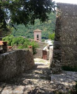 an alley with a stone wall and a building at B&B La Libellula in Pratella