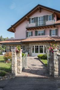 ein rosa Haus mit einem Tor und einer Einfahrt in der Unterkunft T'AMI Hotel Resort Spa in Selvino