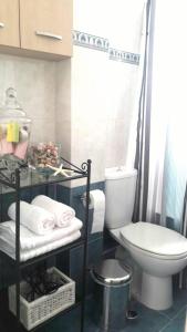 a bathroom with a toilet and a shelf with towels at Luxury Apt Near The Airport in Spáta