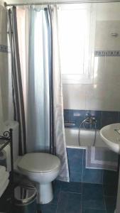 a bathroom with a toilet and a shower and a sink at Luxury Apt Near The Airport in Spáta