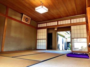 an empty room with a japanese room with a large door at 堺のお宿 旧星賀亭 in Kita-noda