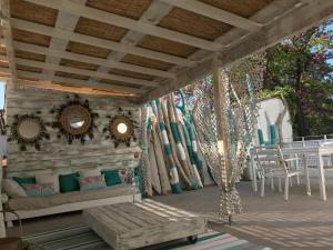 UchaudにあるLe lagon bleuのソファとテーブル付きのポーチ