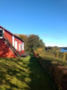 a red building next to a body of water at Lillstugan in Älvkarleby