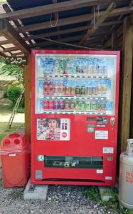 uma máquina de refrigerante vermelha com bebidas em Pension Shishikui em Shishikui
