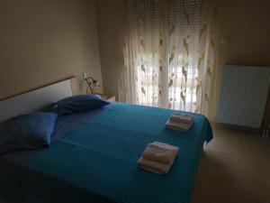 a bedroom with a bed with two towels on it at Apartment Next to Coast in Nea Anchialos