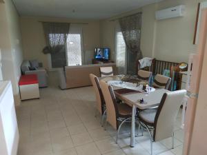 a dining room and living room with a table and chairs at Apartment Next to Coast in Nea Anchialos