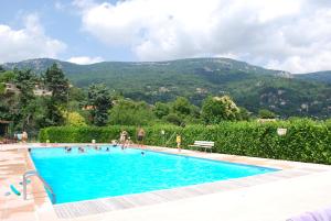 una piscina con gente en ella con montañas en el fondo en Beautiful townhouse in Bargemon en Bargemon