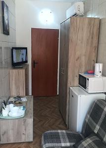 a living room with a microwave and a door at Apartments Astoria HN in Herceg-Novi