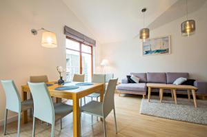 a living room with a table and chairs and a couch at Grand Apartments - Neptun Park. in Gdańsk
