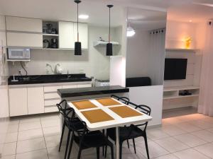 uma cozinha com mesa e cadeiras num quarto em Apartamento Aconchegante Em Arraial Do Cabo em Arraial do Cabo