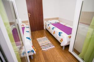 a small bedroom with a bed and a mirror at Agata Apartments in Novalja