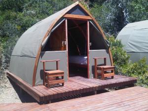 a small tent with two stools on a wooden deck at Koensrust Tented River Camp in Vermaaklikheid