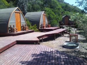 a group of tents with benches and a fire pit at Koensrust Tented River Camp in Vermaaklikheid