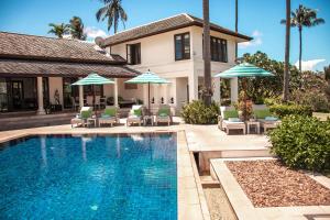 a house with a swimming pool with chairs and umbrellas at Baan Sawan Villa in Bophut