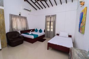 a room with a bed and a couch and a chair at Chrish Residence in Negombo