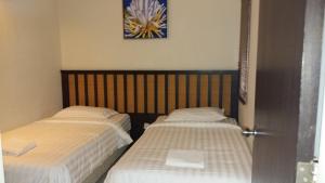 two beds sitting next to each other in a room at Lala House, Gold Coast Morib Resort in Banting
