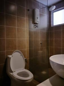 ein Bad mit einem WC, einem Waschbecken und einem Fenster in der Unterkunft Lala House, Gold Coast Morib Resort in Banting