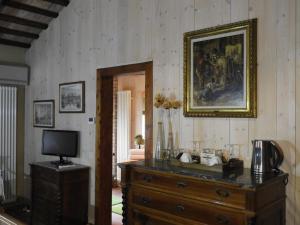 een kamer met een dressoir, een televisie en een schilderij bij B&B Ca' Cinel Asolo in Asolo