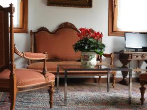 a living room with two chairs and a table with a vase of flowers at B&B Ca' Cinel Asolo in Asolo