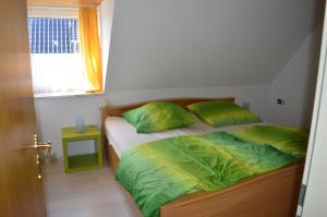 a bedroom with two beds with green sheets and a window at Seglerhafen in Ahrensbök