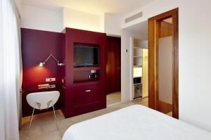 a hotel room with a television and a bed at Hotel Palladium in Palma de Mallorca
