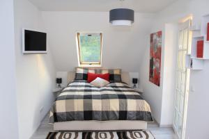 a bedroom with a bed with a checkered blanket at Ferienwohnungen direkt am Wasser in Burg