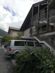 een wit busje geparkeerd voor een gebouw bij Chalet Silvi Residence in Bormio