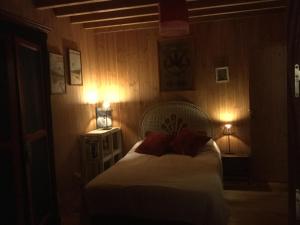 um quarto com uma cama com duas almofadas vermelhas em la maison face au port em Lège-Cap-Ferret