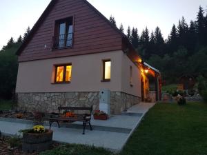 a small house with a bench in front of it at Drevenica pod Horou in Vyšná Korňa