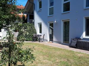 ein blaues Gebäude mit einem Tisch und Stühlen im Hof in der Unterkunft Ferienwohnung Werraglück in Eschwege