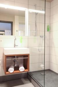 a bathroom with a sink and a shower at Hotel Kunstmühle in Mindelheim