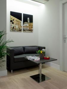 a living room with a black couch and a table at Regola Suite in Rome