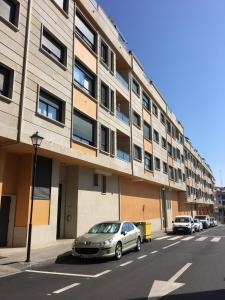 un coche aparcado frente a un edificio en Ático 3 habitaciones en Ribeira, en Ribeira