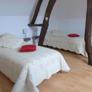 a bedroom with two beds with red pillows at Gîte et Relais Equestre de Marie in Tours-en-Vimeu