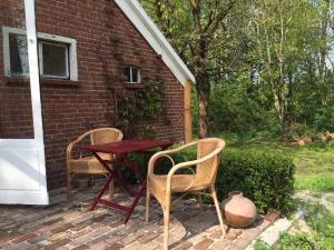 2 sillas y una mesa en un patio de ladrillo en Veenhoes en Vriescheloo