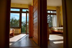 een open deur naar een kamer met een bed en ramen bij Apartamenty Argo in Krakau