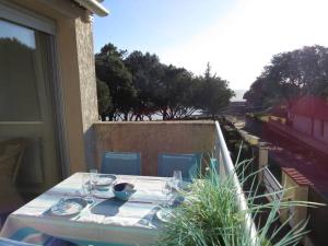 a table with plates and wine glasses on a balcony at 18 Rue de la Corvette in Saint-Palais-sur-Mer