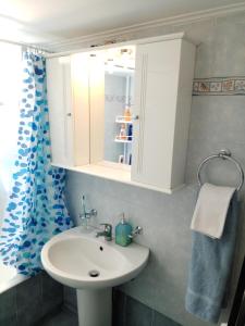 Un baño con un lavabo blanco y un espejo. en Alkiviadis Apartments Artemida, en Artemida 15 fotos más