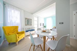 a living room with a yellow chair and a white table and chairs at Villa DOEL in Zadar
