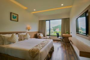 a hotel room with a bed and a large window at Blu Feather Hotel & Spa in Udaipur