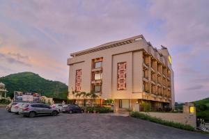 a building with cars parked in a parking lot at Blu Feather Hotel & Spa in Udaipur