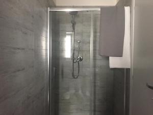 a shower with a glass door in a bathroom at Vuelo in Modugno