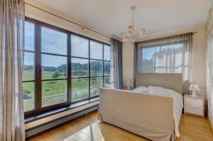 a bedroom with a bed and large windows at Spacious Villa with Large Hall in Mindūnai