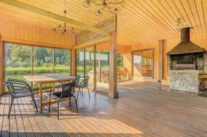 a large screened in porch with a table and a fireplace at Spacious Villa with Large Hall in Mindūnai