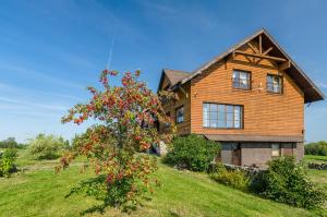a wooden house with a tree in front of it at Spacious Villa with Large Hall in Mindūnai