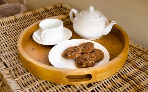 a wooden tray with cookies and a tea pot on it at Raikes Barn in Skipton