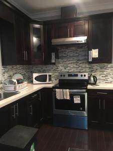 a kitchen with wooden cabinets and a stove top oven at Sandy's House in Vancouver