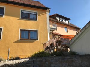 un bâtiment jaune avec un escalier devant lui dans l'établissement Urlaub auf dem Bauernhof Zeller, à Wolframs-Eschenbach